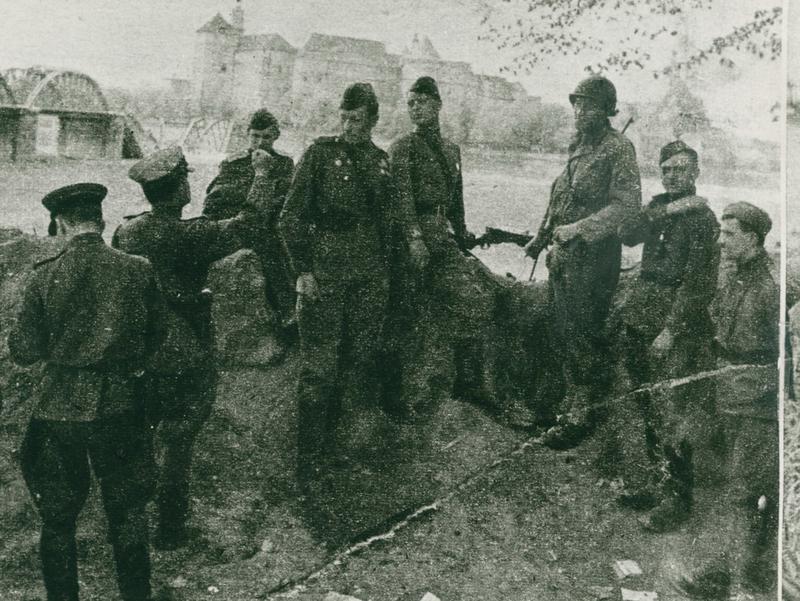 Amerikanische und sowjetische Soldaten am Brückenkopf, im Hintergrund Schloss Hartenfels und die gesprengte Elbbrücke